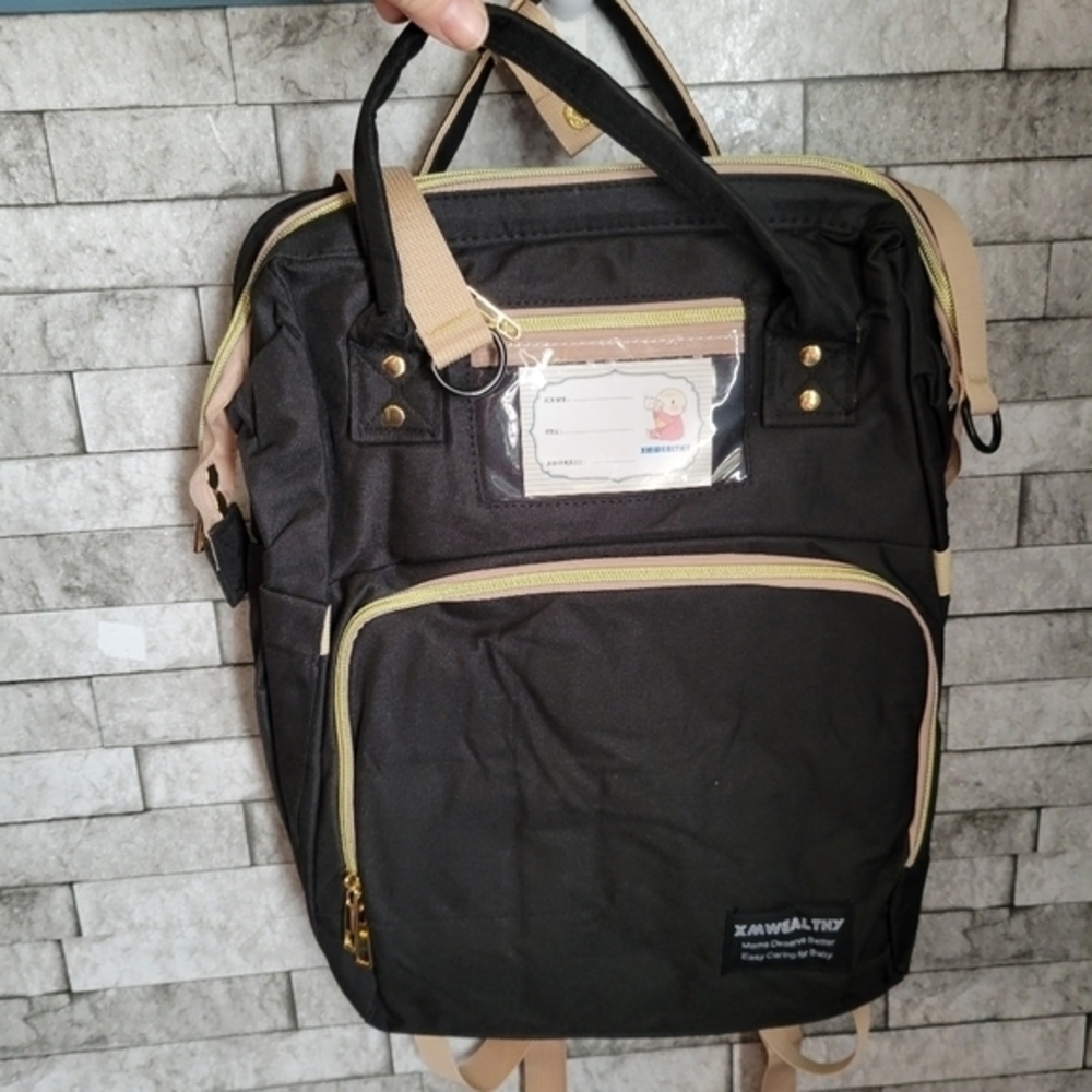 XMWealthy NWOT baby diaper bag with fold out crib, with pad charging port‎